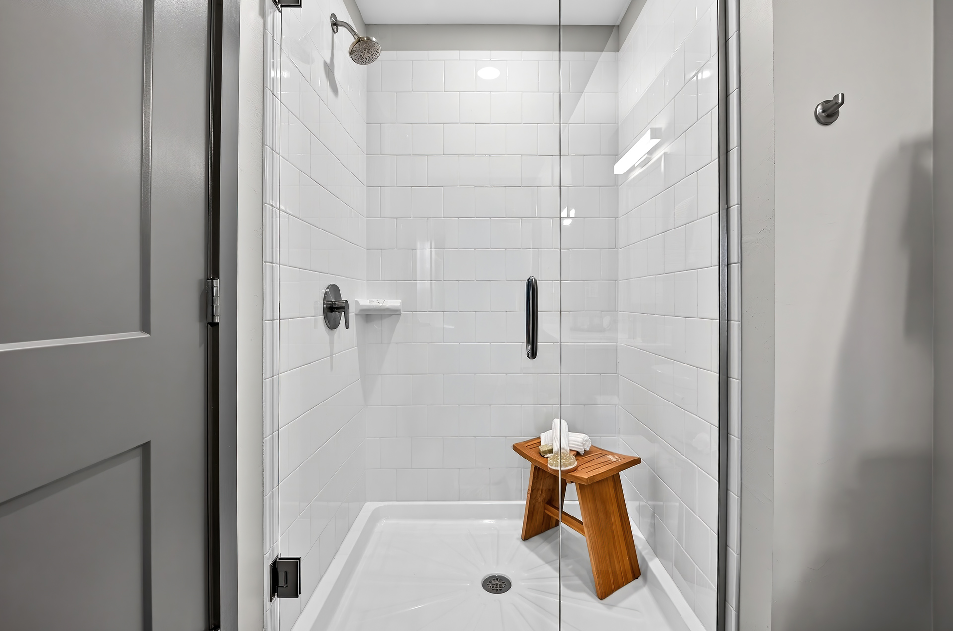 Spa-inspired glass walk-in shower with tile surround in a one-bedroom apartment at Sinclair at Palm Pointe in Fort Myers, FL